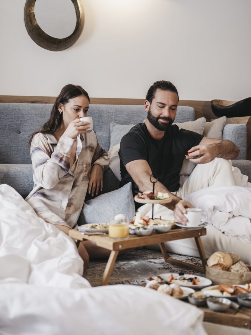 Frau und Mann im Bett am Frühstücken